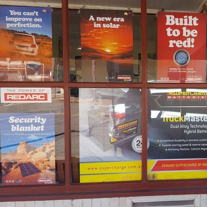The shopfront window at Whyalla Battery Electric, showing REDARC, REDARC Solar and Supercharge Batteries posters behind the glass