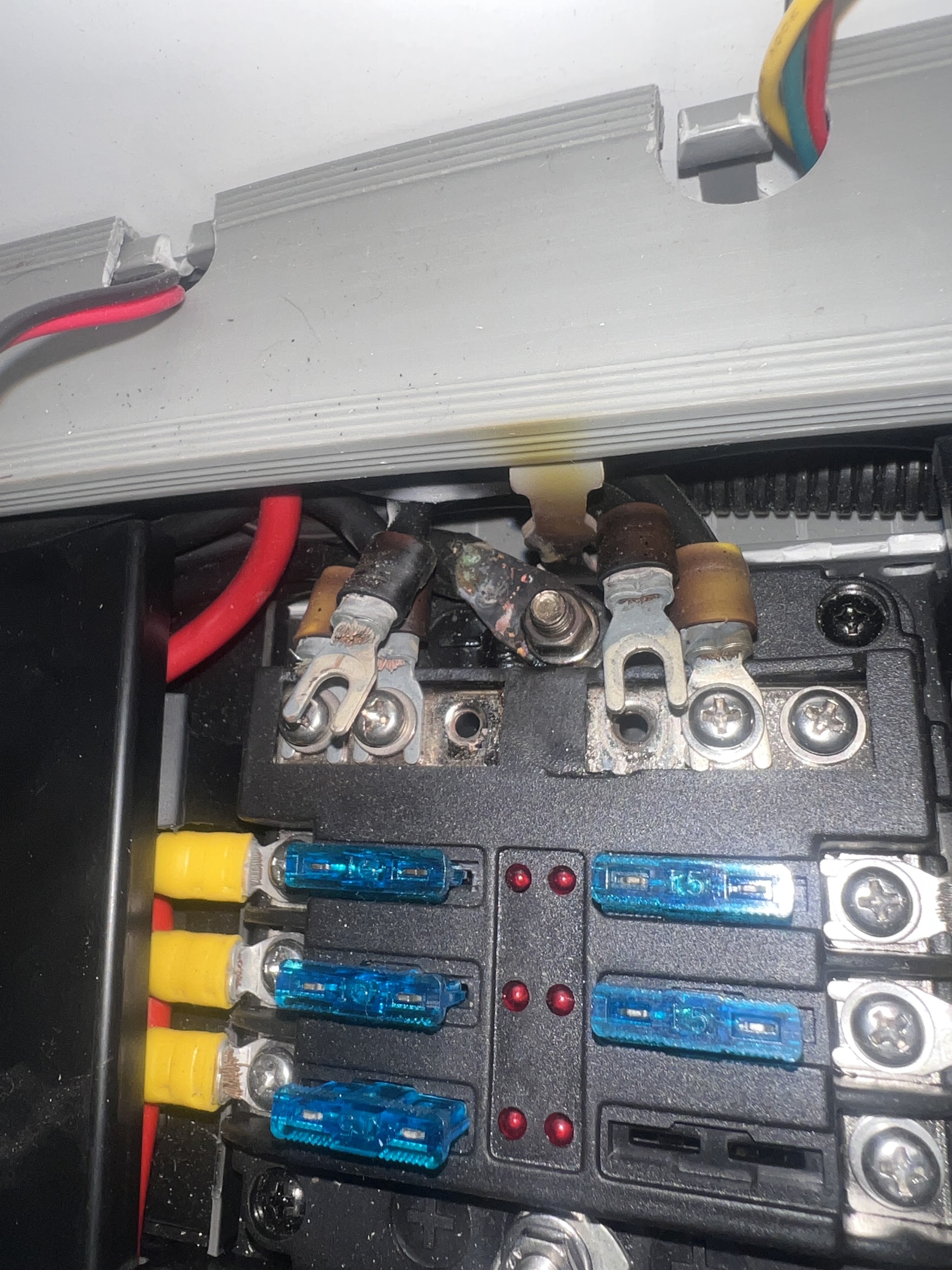 An old corroded terminal block and fuse panel inside a caravan, photographed during a rewiring job before the repair